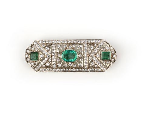 An emerald and diamond brooch, of openwork design, set with an oval-shaped emerald within pave-set diamond surround in yellow