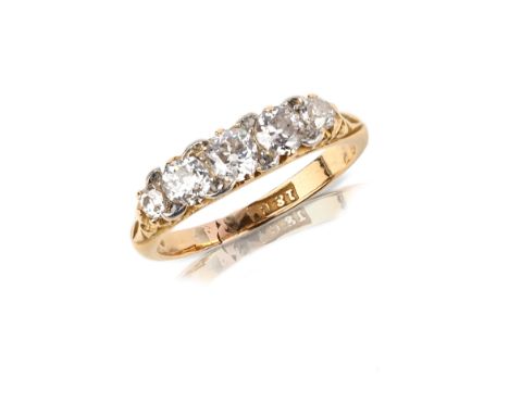 A late Victorian 18ct gold and diamond five-stone ring, set with a sequence of five graduated circular-cut diamonds accented 
