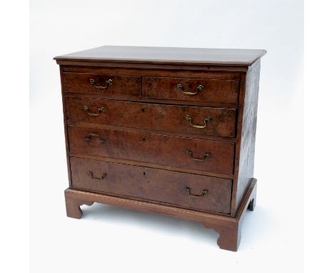 An 18th century oak and burr chest, of two short drawers over three graduated long drawers, below a later top and raised on l