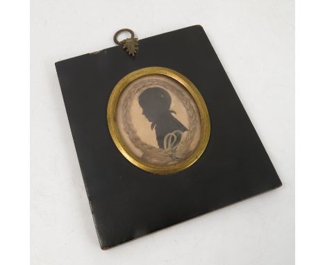 A 19th century oval portrait silhouette, of a young boy, inscribed verso James C Wilde at four years old, framed with a plait