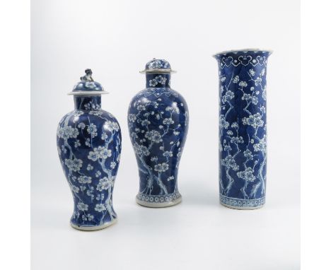 Two Oriental baluster shaped covered vases, decorated with blue and white prunus, together with a similar vase, height 14ins,