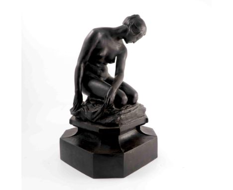 A bronze model, of a kneeling female nude looking to the ground, kneeling on a cushion, on a shaped base, height 18ins