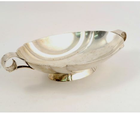 A silver bowl, of shaped oval form, with a pair of ring handles and raised on an oval foot, Sheffield 1936, weight 15oz