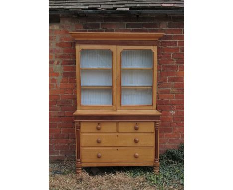 A 19th century light oak cabinet, the upper section having two glazed doors opening to reveal shelves, fitted with two short 