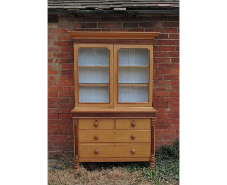 A 19th century light oak cabinet, the upper section having two glazed doors opening to reveal shelves, fitted with two short 