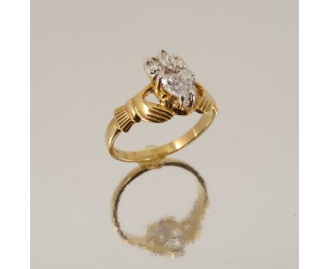 A diamond 14 carat gold Claddagh ring, the heart shaped stone of approximately 0.45 carats with a trio of small diamonds abov