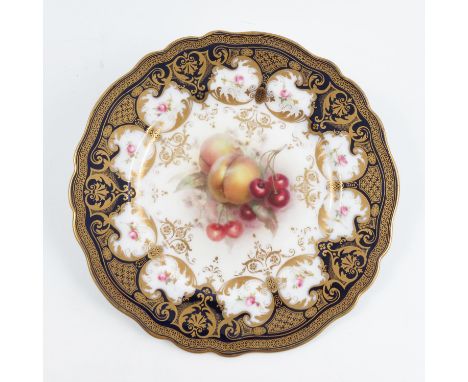 A Royal Worcester plate, decorated with fruit to a blue and gilt border, by Seabright, dated circa 1912, diameter 8.75ins, to
