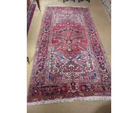 A red ground handmade Persian Heriz carpet - 3.30 m x 1.75