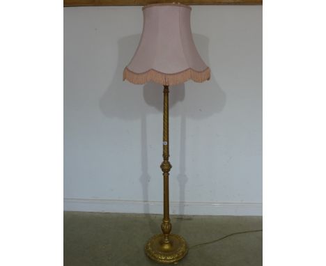 A late Victorian hardwood standard lamp with gilt finish and pink shade