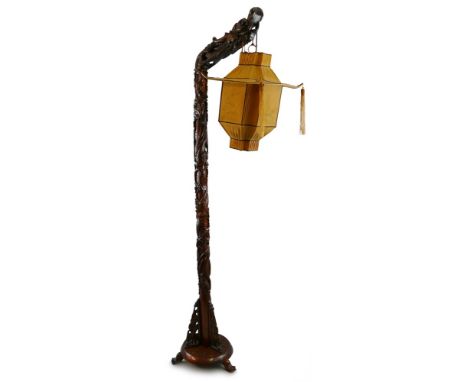 A Chinese hardwood standard lamp, of signpost form, carved and pierced all over with a spiralling dragon, the floral carved c