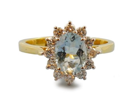 An 18ct gold aquamarine and diamond cluster ring, claw set with an oval mixed cut stone bordered by ten brilliant cut diamond