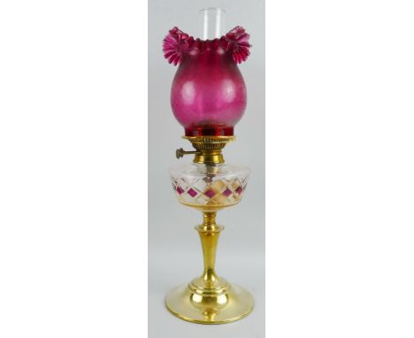 A late Victorian table oil lamp, with plain stepped circular brass base, tapering column with beaded rim supporting a cranber