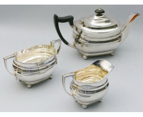 A three piece silver tea service, Sheffield 1942, of oblong baluster form, raised on four ball feet, ebony finial and handle,