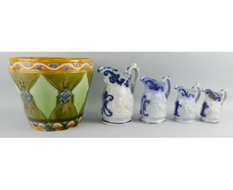 A Victorian set of four graduated jugs, each moulded with two boys seated playing cards, blue painted scrolls and mask lip, l