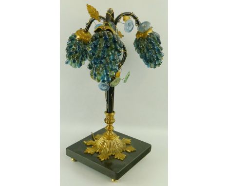 A table lamp, with polished black granite square plinth and cast brass snowflake shaped base, supporting three tubular iron b