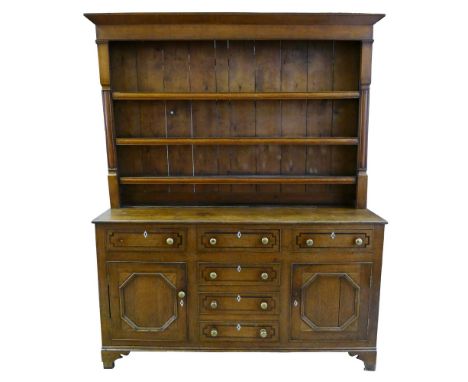 A George III oak Welsh dresser, the associated top with chamfered cornice over three graduated shelves with moulded front edg
