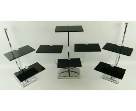 A set of three Art Deco style tiered display stands, each with tubular chrome frame, oblong base and black vitrolite shelves 