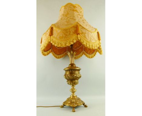 A cast yellow metal table lamp, the stepped circular base with four paw feet, knopped stem, urn-shaped top with acanthus leav