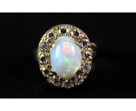 A beautiful yellow metal (tested 14ct gold and foreign hallmark) ring set with a bright opal surrounded by diamonds. (P) Appr