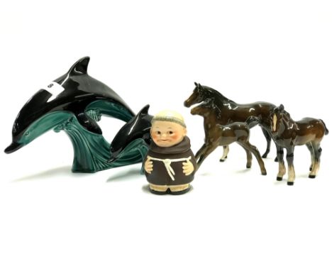 Two Poole pottery dolphins, three Beswick horses and a Goebel monk.