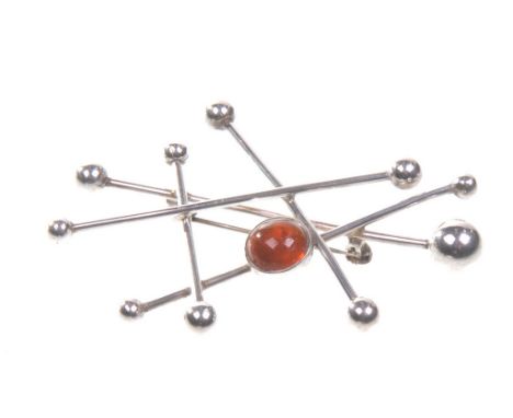 Neiels Erik From: A circa 1960's Danish silver and amber satellite brooch
Of abstract form set with a round cabochon amber, s