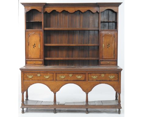 An oak and inlaid Montgomeryshire style highback dresser
With an inverted dentil cornice above a shaped frieze, three plate r