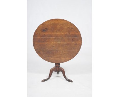 An early 19th Century oak tripod table
With a 83cm diameter four plank top raised upon a baluster and vase turned shaft, down