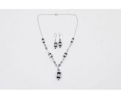A paste and white metal necklace and earring set
The necklace with clear paste barrel shaped drop with black banding to the a