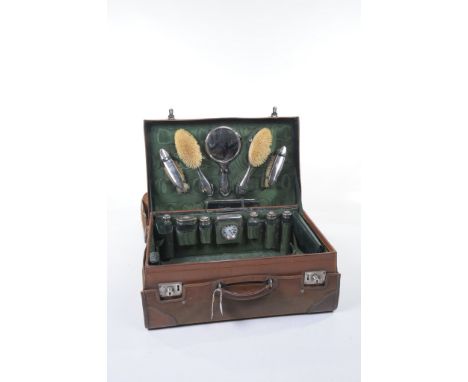 A vintage leather travelling vanity case
The hinged cover initialled LMB with a green sateen lined interior and fitted with a