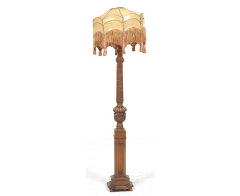 A Jacobean style oak standard lamp, early 20th Century
With a leaf and berry carved column supported on a leaf carved lobed v