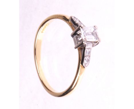 An emerald cut diamond solitaire ring
The emerald cut diamond of an estimated 0.33cts, four claw set to diamond set shoulders