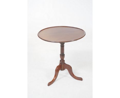 A 19th Century mahogany tripod table
With a 64cm diameter top with a fluted raised rim raised upon a turned vase shaped shaft