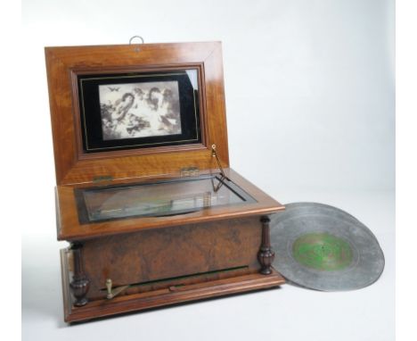 A Victorian walnut 30cm symphonion 
The centre drive disc playing on two combs, one stamped 64414, contained in a walnut vene