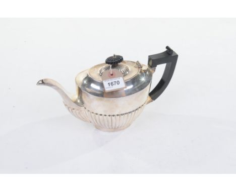 A George V hallmarked silver teapot
Of vase form with an ebony cushion finial above a lobed surbase, ebonised angular handle,