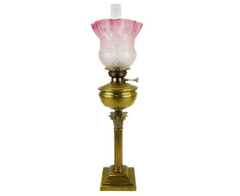 A Victorian brass oil lamp with an etched cranberry glass shade.  With brass corinthian style base, brass oil reservoir and a