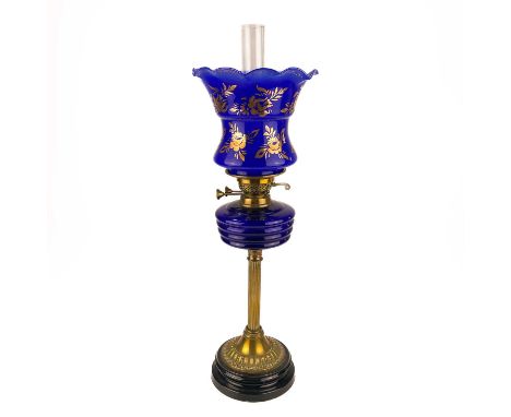 A Victorian brass oil lamp with a blue glass oil reservoir and blue glass shade.  Raised on a circular base, height 69cm.No c