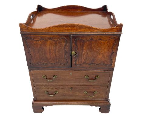 A late George III mahogany nightstand. With gallery top above two doors with shaped panel doors, above a converted lower draw