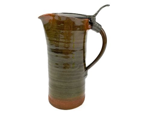 A Leach Pottery an early red clay jug with a hinged pewter lid. Impressed marks, height 18cm.There is a U shape glued chip on