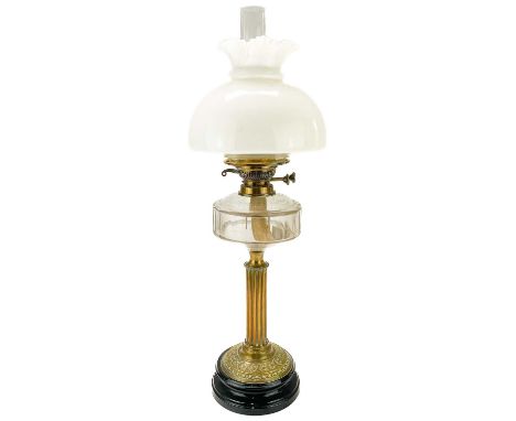 A Victorian brass oil lamp with a glass reservoir and white glass shade.  Raised on a circular base, with clear glass oil res