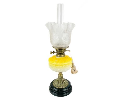A Victorian brass oil lamp with moulded yellow glass reservoir and etched glass shade. Raised on a circular base, height 60cm