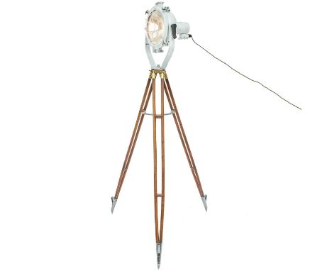 A ship's cargo deck light on a tripod stand. White painted, with a metal grille, the stained beech tripod with brass and allo