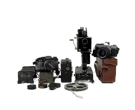 A Pathescope Motocamera. Together with a Pathescope PB Ex Cine projector with accessories, an Olympus OM4 and Olympus OM2 cam