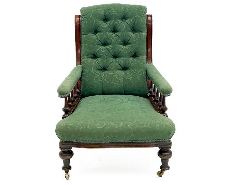 A Victorian mahogany framed armchair. with button back and upholstered sprung seat, the padded arms with turned spindles and 