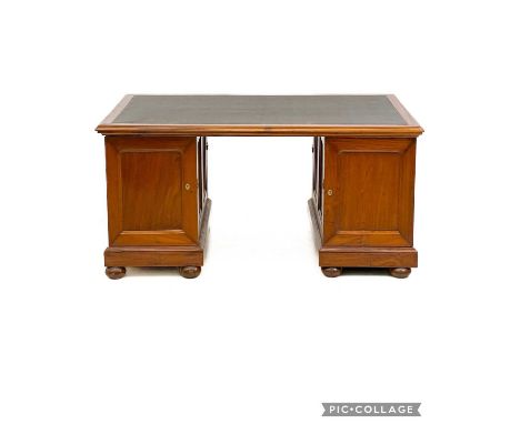 A teak partners desk. Indian, mid 20th century, with a rexine writing surface, each pedestal fitted a door, one to each side 