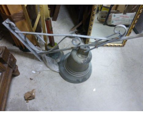 A metal bell on a wall bracket, another with another bell