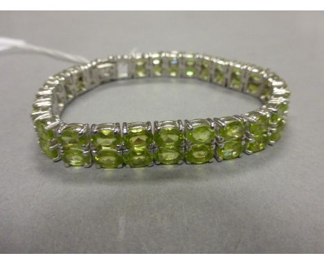 A good substantial silver peridot bangle set with 50 peridots over 20cts 