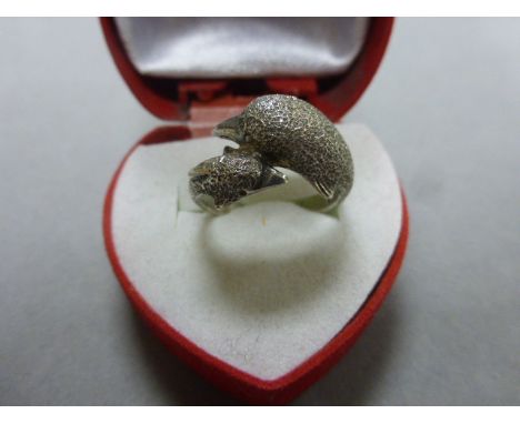 A silver ring in the form of two dolphins
