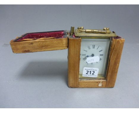 A French brass cased carriage clock, with a white enamel dial, roman numerals, cased and key