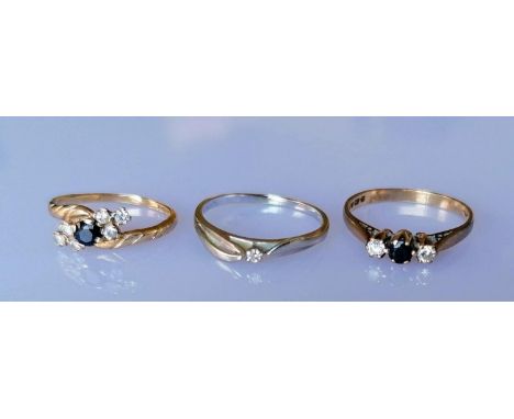 A three-stone diamond and sapphire ring, another flanked with six diamonds, both hallmarked and a diamond solitaire ring on 1