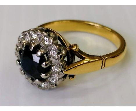 A sapphire and diamond cluster ring on an 18ct yellow gold setting: the sapphire approx. 0.75 carat, stamped, size N, 6.64g